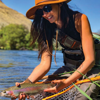 Kayla Lockhart releasing a wild trout